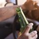 man holding a bottle of alcohol while driving. DUI vs. DWI in California What You Need to Know